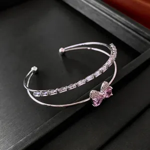 Double-layer silver bangle featuring a pink zircon bow and rectangular crystals