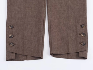 Détail du bas de pantalon marron avec boutons ambrés vintage et fente latérale stylée