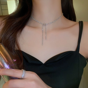 Macro detail of silver knot fringe necklace with zircons and matching multi-layer ring