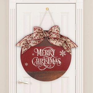 Detail of wooden Merry Christmas door sign with red bow and berry patterns on white door