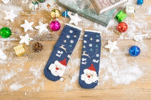 Close-up of navy blue Christmas socks with Santa Claus, reindeer patterns and fluffy cuffs