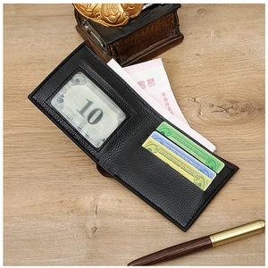 Detailed view of black woven short wallet with ID window and card slots on a wooden desk