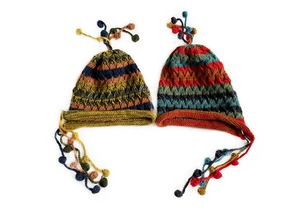 Detailed view of colorful handmade knit wool beanies with ethnic stripes and tassels