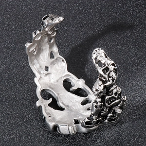 Gros plan d'une bague ouverte gothique argentée à tête de mort avec gravures évidées