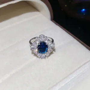 Bague fleur de luxe avec pierre bleue et pétales de zircon étincelants dans son écrin