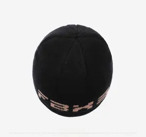 Vista dall'alto di un berretto in maglia nera con motivo jacquard beige sul bordo