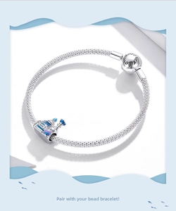 Detail of S925 silver mesh bracelet with a colorful enamel castle charm and engraved clasp