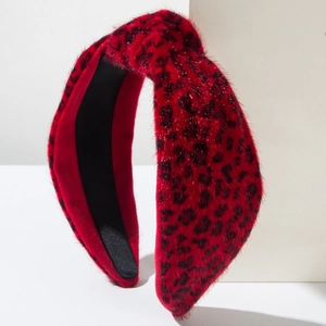 Détail du serre-tête en peluche léopard rouge avec nœud torsadé et texture douce