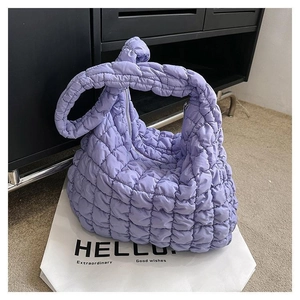 Detail of lilac quilted puffer bag with textured knot handle and large cloud-like design