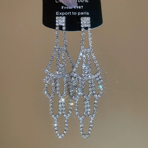 Detail of silver long tassel earrings with sparkling rhinestones and hollow geometric drop