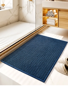 Detailed close-up of dark blue chenille bath mat with thick absorbent textured granules