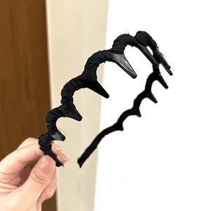 Detail of black wavy non-slip headband with fabric texture and inner grip teeth