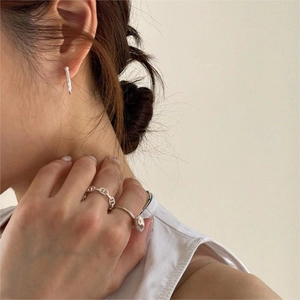 Detail of 925 sterling silver anchor chain ring and u-shaped stud earrings on model