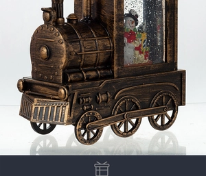 Detail of vintage bronze train music box with a snowman inside the crystal snow globe