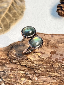 Macro detail of natural labradorite gemstone on vintage textured adjustable metal ring