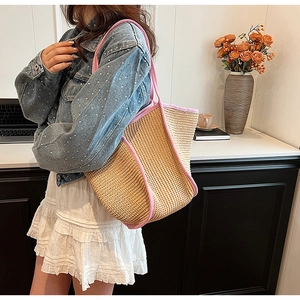 Detail of hand-woven straw bag featuring pink trim and natural texture for summer