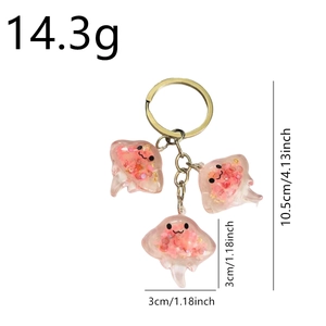 Luminous pink glitter resin manta ray keychain with measurements on white background
