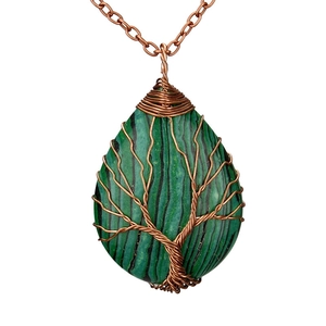 Macro shot of copper wire wrapped tree of life pendant with green malachite stone
