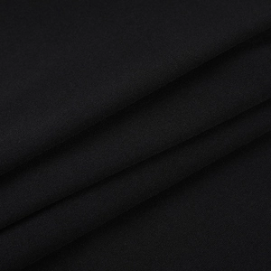 Gros plan sur la texture du tissu noir de qualité supérieure et le drapé de la robe