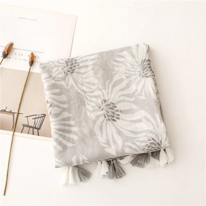 Détail de l'écharpe à fleurs avec texture coton-lin douce et finitions à franges
