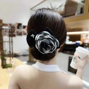 Detail of a large chiffon floral hair clip with crystal butterfly on model's hair