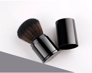 Detail of retractable makeup brush with black case and soft brown gradient bristles