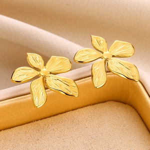 Elegant gold flower stud earrings with textured petals in a velvet jewelry gift box