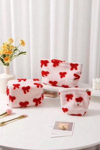Detailed set of three pink cosmetic bags with 3D red bows and H&R BAG logo tags
