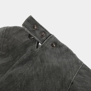 Detailed close-up of dark grey twill fabric texture and vintage silver metal buttons