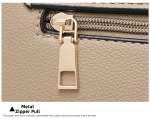 Detailed macro view of the smooth champagne gold metal zipper pull on beige lychee leather