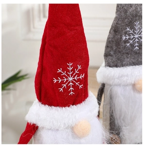 Nahaufnahme von Weihnachtswichteln mit roten und grauen Schneeflockenhüten und Bart