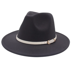 Detail of black wool fedora featuring a white faux leather strap and golden buckle