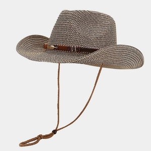 Detail of woven straw cowboy hat featuring metal feather buckle and brown ribbon trim