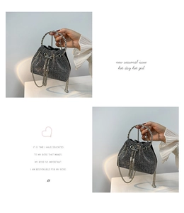 Detailed close-up of a silver rhinestone bucket bag featuring metal handles and chain