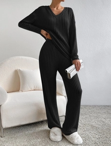 Detailed view of the V-neck knit top and wide-leg trousers in black ribbed fabric