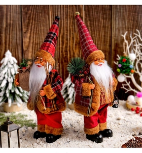 Standing Santa Claus figurines with red plaid outfits and gift bags in Christmas scene