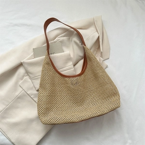 Chic beige woven straw tote bag with brown leather trim for summer beach travel