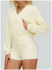 Detail of light yellow hooded two-piece set with white contrast trim and front pocket