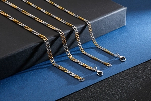Detail of four two-tone gold and silver Cuban link necklaces with lobster clasps