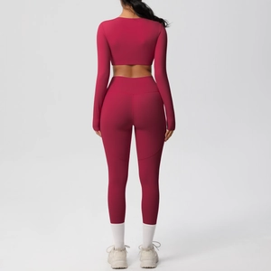 Detail view of burgundy high-waist yoga pants and long sleeve crop top from back