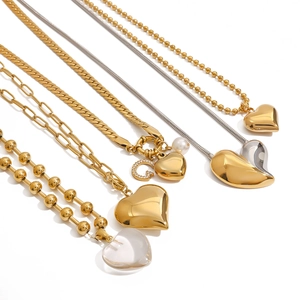 Detail shot of five gold and silver heart pendant necklaces with diverse chain styles