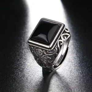 Macro shot of vintage silver ring with black square stone and filigree detailing
