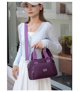 Purple nylon crossbody bag modeled outdoors with multi-layer zipper and elegant metal logo