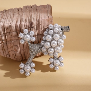 Elegant poodle brooch with white pearls and sparkling crystals on natural wood background