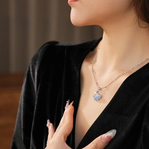Detail of light blue ginkgo leaf pendant with pearl on a silver bead necklace chain