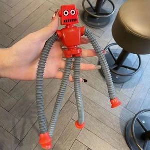 Close-up of red and grey telescopic pop tube robot toy with suction cup limbs