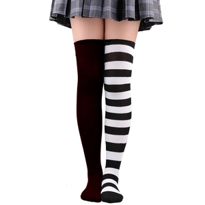 Détail de chaussettes hautes montrant des rayures asymétriques et un tricot bordeaux uni