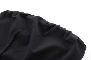 Detail shot of the black ruched fabric texture on a stylish strapless dress for women