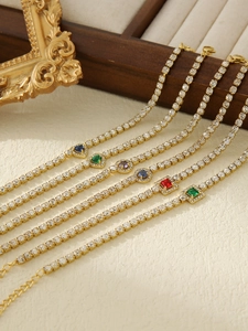 Macro shot of gold-plated tennis bracelets with multicolored heart and square gems