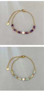 Detailed view of natural stone beaded bracelets with white pearls and gold chains
